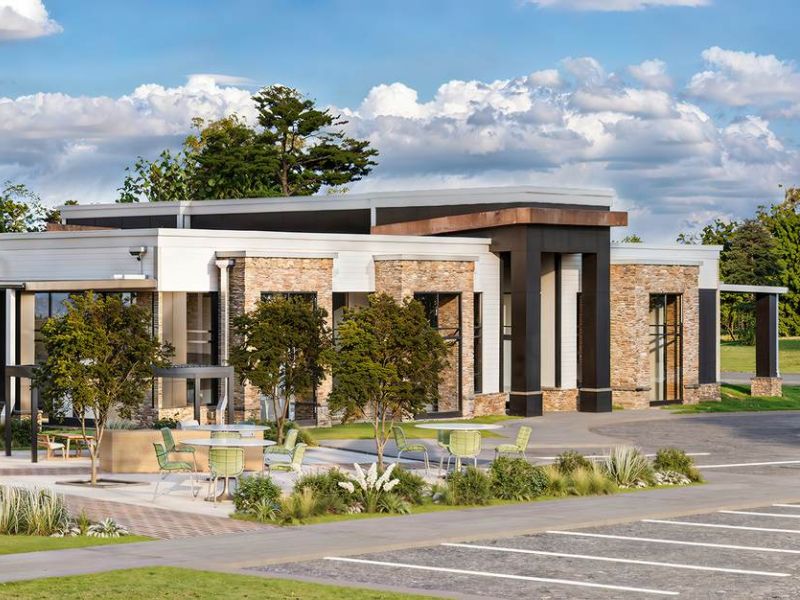 Exterior view of the Linden Village clubhouse featuring modern architecture, stone accents, and lush landscaped surroundings.