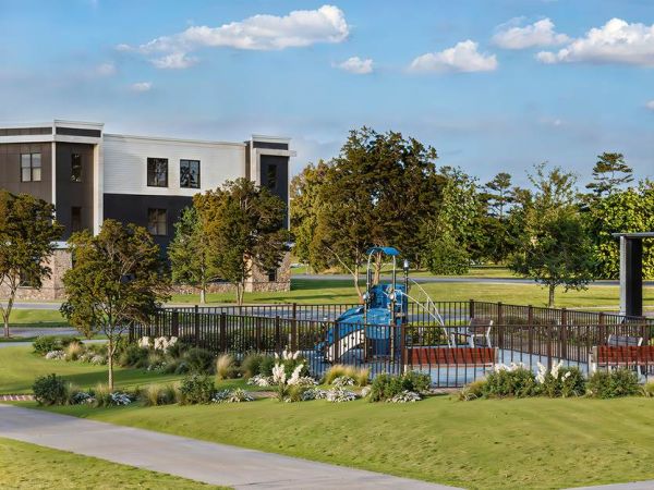 Exterior view of the Linden Village clubhouse featuring modern architecture, stone accents, and lush landscaped surroundings.